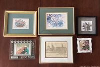 Six framed artworks/photos arranged together including a signed lithograph by Brent Heighton and five other frames of varied styles and images.