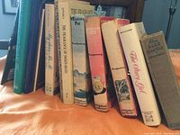 Spine view of 11 books by Lucy Maud Montgomery, including Anne of Green Gables Treasury, My Dear Mr. M, The Poetry of Lucy Maud Montgomery, The Fragrance of Sweet-Grass, Mistress Pat, The Story Girl, The Blue Castle.