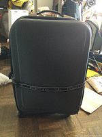 Full view of the hard shell suitcase showing the exterior and handle on top.