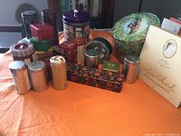 Overall view of assorted storage tins including round, square, and rectangular shapes in various colors and decorative patterns.