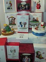 Overview image showing multiple Hallmark Keepsake Peanuts Christmas ornaments with original boxes and assembled scenes.
