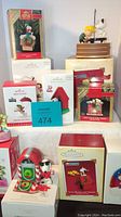 Boxed Hallmark Keepsake Peanuts Christmas ornaments including a Snoopy skiing figure, a doghouse, and other assorted character ornaments.