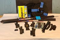 Full layout of PECO Streamline HO scale model train rails, foam track-bed rolls, snap switches including packaged and loose items laid out on white surface