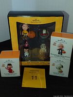 Full display of boxed Peanuts Gang Halloween mini ornaments including the Great Pumpkin boxed set, individual boxed ornaments of Lucy, Charlie Brown, and Snoopy.