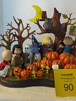 Full view of the Peanuts Halloween figurine set showing characters with pumpkins and tree base.