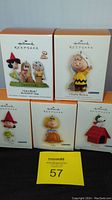 Lot contents showing five Hallmark Keepsake Peanuts Halloween ornaments in boxes, featuring Snoopy, Sally, Lucy, Charlie Brown, and The Peanuts Gang.