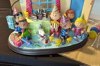 Front view of Peanuts birthday scene figurine showing characters in party hats, presents, and cake details.