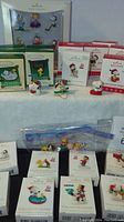 Wide view showing multiple unopened Hallmark Keepsake Peanuts miniature ornaments and some displayed figures