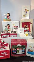 Front view of the lot showing multiple Hallmark Peanuts Keepsake ornaments in original boxes arranged on a table.