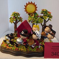 Full view of the Peanuts Thanksgiving figurine scene with characters, trees, and doghouse with fall leaves base.