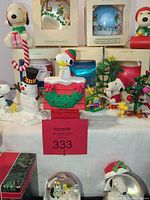Photo of multiple Snoopy-themed Christmas ceramic figurines and snow globes