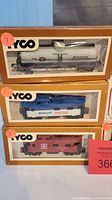 Three boxed Tyco brand train cars: Diamond tanker, Midnight Special tanker, and red caboose in original packaging.