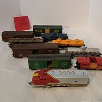 Full set of ten model train cars arranged together showing various freight cars and the Santa Fe locomotive in front.