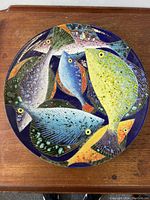 Top-down close-up of the colorful fish pattern artwork on the bowl.