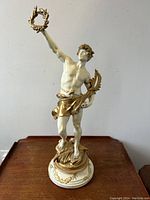 Front full view of statue on wooden surface against wall