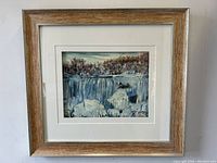 Frontal view of framed oil painting showing winter scene of American Falls with ice and snow.