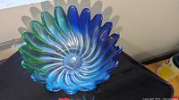 Top view showing the full petal-shaped swirl design and the vibrant transition of greens and blues in the glass bowl.