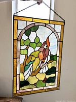 Panel held up by chain in front of window to show translucency