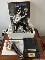 Box showing black and white image of Elvis on stage with guitar, labeled 'Elvis Telephone Sings and Dances' with Official Product and Telemania logos.