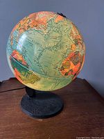 Front view showing the western hemisphere including South America and part of Africa with clear label of Atlantic Ocean. Globe mounted on black oval textured base.