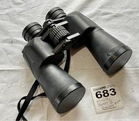 Full view of Minolta Classic II binoculars showing rubber body, lens caps, central focus wheel, and carrying strap.