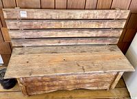 Front view of cedar wooden storage bench showing slatted backrest and hinged flat seat.