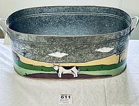 Front view of the oval metal cistern showing a black and white painted cow with pasture and sky background.