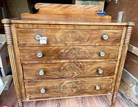 Front view of the entire dresser showing all four drawers with decorative round knobs, dovetail joinery visible on the side of drawers, and turned column legs.