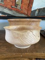 Small handmade wooden bowl with visible wood grain and curved lip