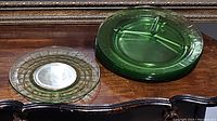 Set of four circular green glass dinner plates and one smaller sandwich plate, showing ribbing under light sheen.
