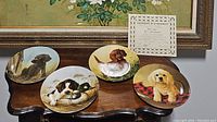 Five collector plates featuring different dog breeds displayed on a wooden surface with certificate of authenticity visible.