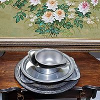 Stacked metal platters and bowls showing lot contents and condition.