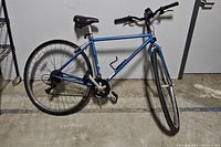 Right side profile of blue Specialized Hardrock mountain bike showing frame, wheels, and pedals.