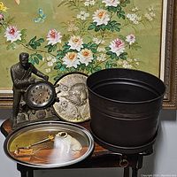 Photo showing all four items: FDR metal clock, bronze wall plate, metal planter, RCA Nipper tin tray