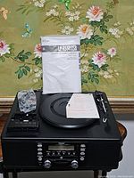 Full view of the Teac LP-R550USB showing the turntable, control panel, manual, and cables placed on top.