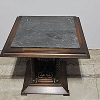 Full top view of wood cocktail table showing square gray marble insert and wooden frame.