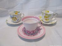 Three vintage Royal Albert teacup and saucer sets displayed together showing floral patterns and delicate porcelain cups and saucers.