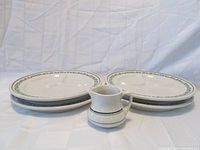 Green creamer and four divided luncheon plates arranged in two stacks with the creamer in front
