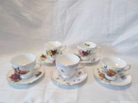 Five Ridgway Potteries Queen Anne teacup and saucer sets shown together, each with unique floral patterns and gold trim.
