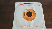 Photo of the 45rpm vinyl record "More Than A Feeling" by Boston showing the orange label and WEA Music of Canada sleeve.