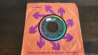 Duran Duran The Reflex 45rpm vinyl single in orange Mercury sleeve with purple arrows, record visible center label showing track info.