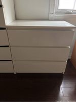 Front view of white MDF dresser showing three closed drawers and simple design.