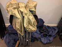 Folded beige collapsible base frame components and blue fabric bed partially visible beneath.