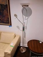 Full view of metal floor lamp standing beside furniture showing overall design and height.