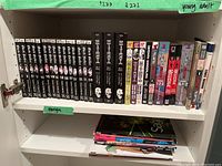 Shelf view of multiple manga volumes including Black Butler, Death Note, Fullmetal Alchemist, and Hellsing showing spines and titles.