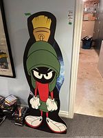 Full view of the freestanding Marvin the Martian cardboard figure showing character's body and outfit