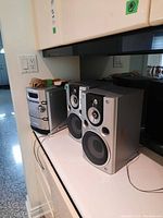Full stereo system with 6-CD changer and two speakers on kitchen counter.
