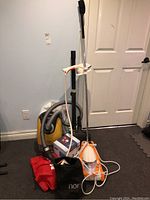 Full lot photo showing yellow Miele vacuum, Noristeam steamer, and accessory bags.