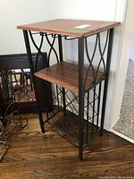 Wine shelf with wood surfaces and black metal frame, showing top, middle shelves, and lower wine bottle rack.