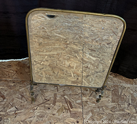 Full view of the front of the mirror showing brass frame and mirror glass with rounded corners.